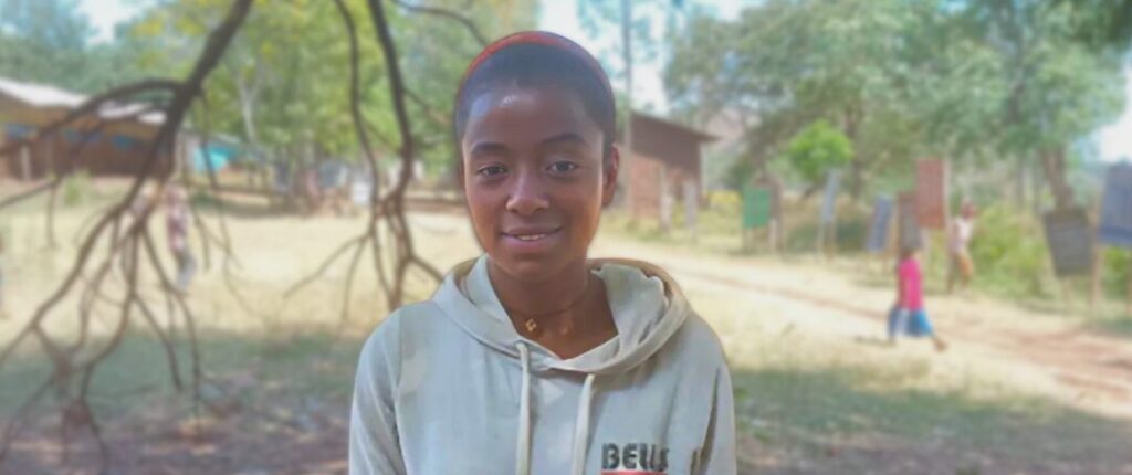 Hana Hailu, a Grade 8 student at Shochora Primary School, smiles outside her classroom after water was restored to the school.